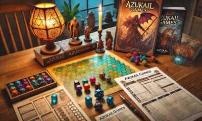 A table setup with Azukail Games resources, including game supplements, dice, and a tabletop RPG map.