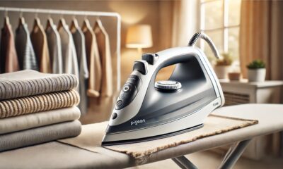 A sleek and modern Pigeon Iron Box on an ironing board with neatly pressed clothes in the background.